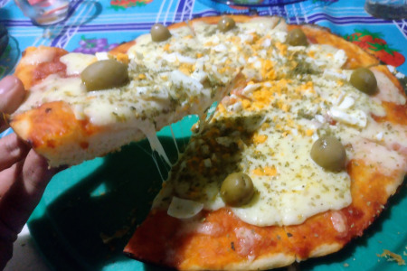 a slice of pizza being picked from a cutting board